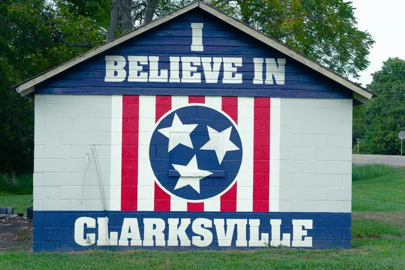 Painted barn-style sign reading I Believe in Clarksville with the Tennessee tri-star